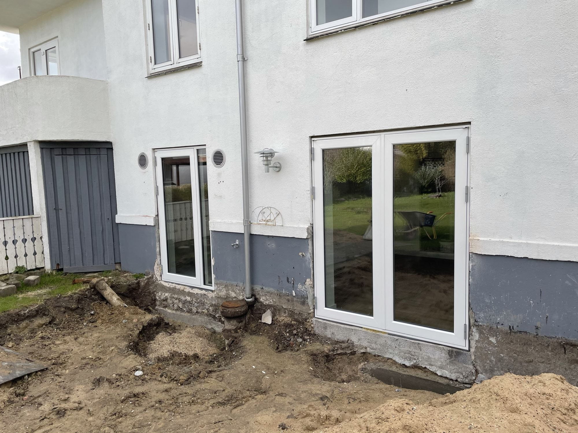 I det ene af de tre huse i projektet Sunde Boliger Renovering (en bungalow fra 1937) var nogle af indeklimaudfordingerne blandt andet problemer med fugt i kælderen pga. tørring af tøj indendørs og manglende dræn og fugtisolering. Derfor er der ved at blive etableret et nyt vaskerum med ny udgang mod haven, hvor der placeres et nyt overdækket tørrestativ. På den måde bliver det enkelt og nemt at tørre tøj udendørs, så fugten kommer ud af huset med det samme. Samtidig spares energi og slid på tøj fra tørretumbler. I det tidligere vaskerum bliver der skabt et helt nyt rum, som godkendes til beboelse ved kommunen. Dermed får det beskedne hus flere nyttige kvadratmeter. Der bliver isoleret i gulvet og på ydervægge, der drænes og udrettes terræn samt etableres ny udgang til haven. Samlet bliver det nemmere at benytte havens uderum, og opholde sig mere udendørs - det bedste 'indeklima'.