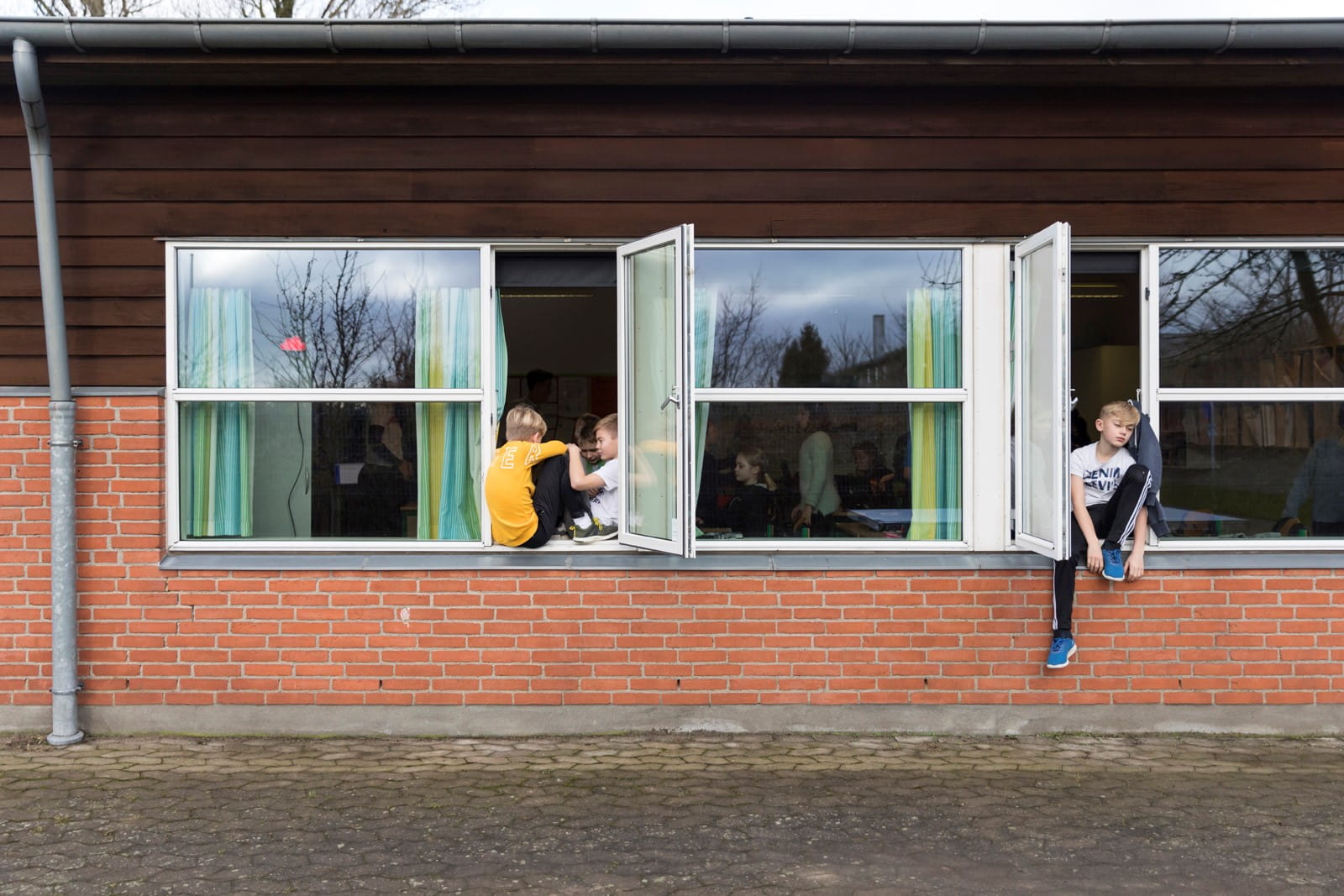 En gruppe skoleelever har åbnet vinduet for at få frisk luft ind i klasselokalet. 