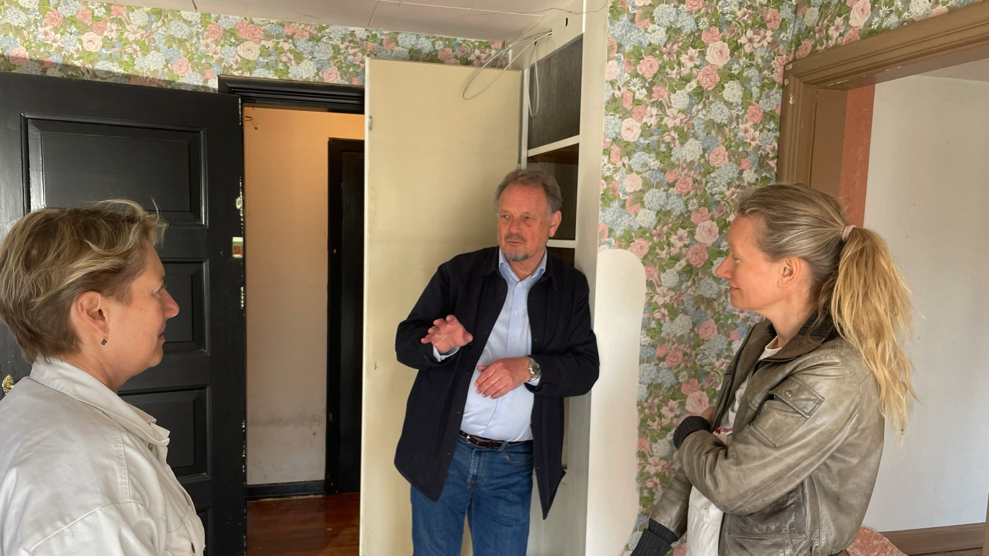Realdania By & Bygs arkitekt Frants Frandsen i samtale med Nationsmuseets konservatorer, Line Bregnhøi (tv.) og Johanne Bornemann Mogensen under farveundersøgelserne i Ejnar Ørnsholts eget hus. Bag det blomstrede tapet og lag af maling fandt konservatorerne soveværelsets oprindelige blå farve, som i dag er genskabt. Bemærk den lille farvetrappe på den sorte dør, som viser dørens farver gennem tiden. 
